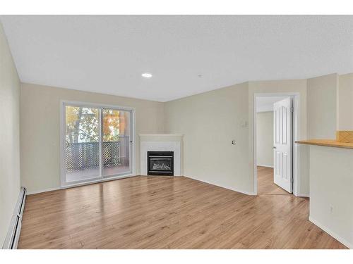 8317-304 Mackenzie Way Sw, Airdrie, AB - Indoor Photo Showing Living Room With Fireplace