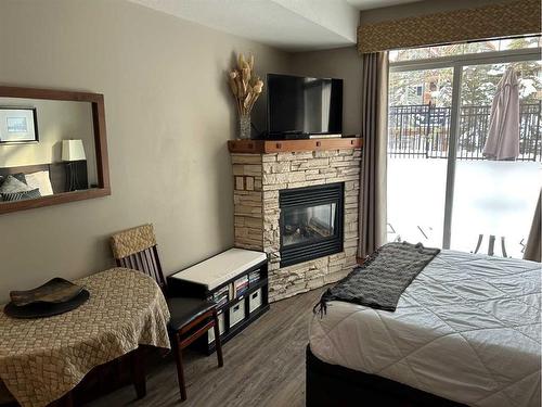 112-190 Kananaskis Way, Canmore, AB - Indoor Photo Showing Bedroom With Fireplace