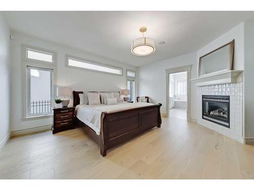 11 Aspen Ridge Lane Sw, Calgary, AB - Indoor Photo Showing Bedroom With Fireplace