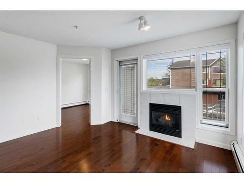 11-7720 39 Avenue Nw, Calgary, AB - Indoor Photo Showing Living Room With Fireplace