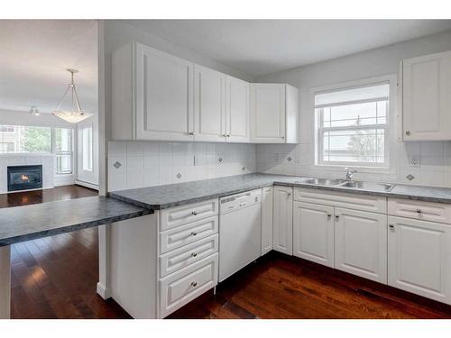 11-7720 39 Avenue Nw, Calgary, AB - Indoor Photo Showing Kitchen With Fireplace With Double Sink