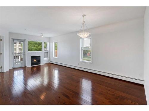 11-7720 39 Avenue Nw, Calgary, AB - Indoor Photo Showing Living Room With Fireplace