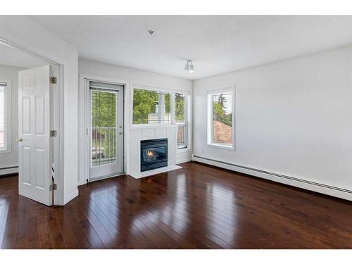 11-7720 39 Avenue Nw, Calgary, AB - Indoor Photo Showing Living Room With Fireplace