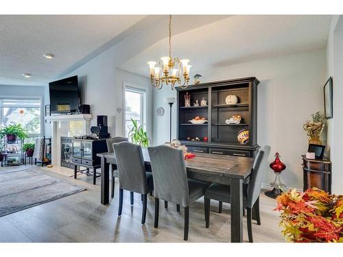 105 Pump Hill Landing Sw, Calgary, AB - Indoor Photo Showing Dining Room With Fireplace