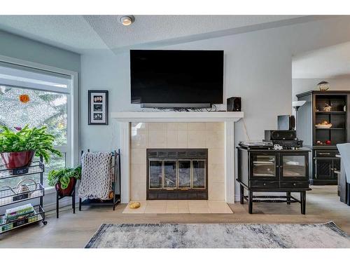 105 Pump Hill Landing Sw, Calgary, AB - Indoor Photo Showing Living Room With Fireplace