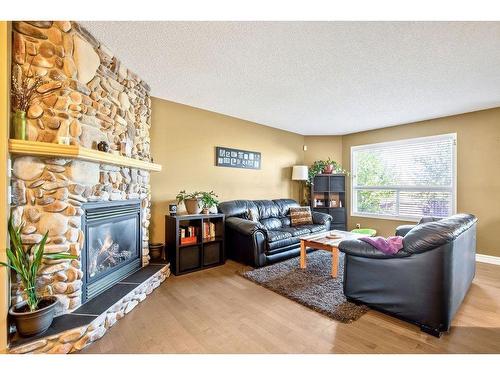 145 Crystal Shores Grove, Okotoks, AB - Indoor Photo Showing Living Room With Fireplace