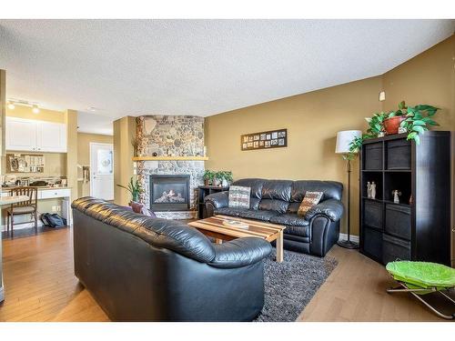 145 Crystal Shores Grove, Okotoks, AB - Indoor Photo Showing Living Room With Fireplace