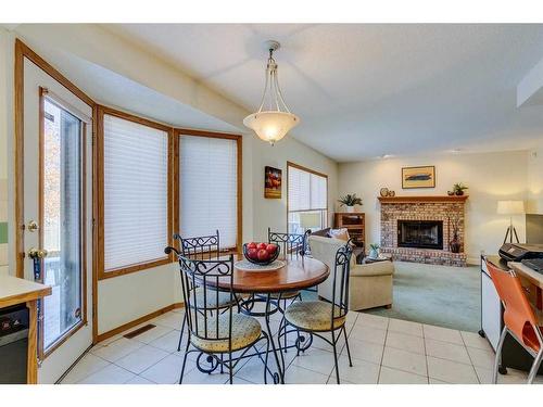 56 Woodford Close Sw, Calgary, AB - Indoor Photo Showing Dining Room With Fireplace