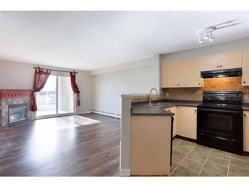 211-17 Country Village Bay Ne, Calgary, AB - Indoor Photo Showing Kitchen With Fireplace