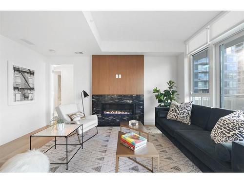 303-128 Waterfront Court Sw, Calgary, AB - Indoor Photo Showing Living Room With Fireplace