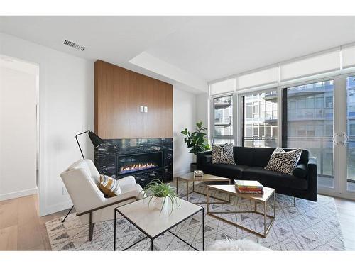 303-128 Waterfront Court Sw, Calgary, AB - Indoor Photo Showing Living Room With Fireplace