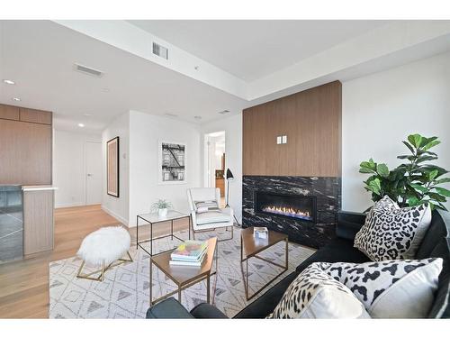 303-128 Waterfront Court Sw, Calgary, AB - Indoor Photo Showing Living Room With Fireplace