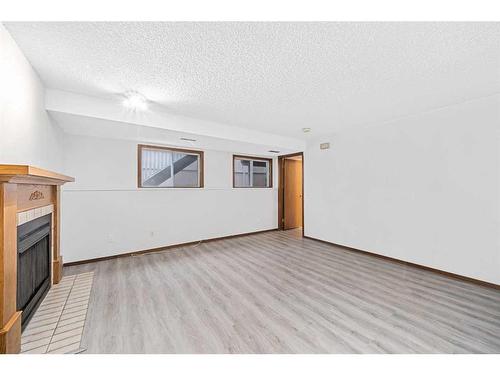 211 Sandstone Drive Nw, Calgary, AB - Indoor Photo Showing Other Room With Fireplace