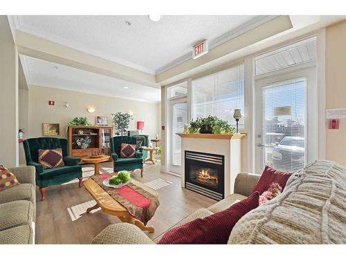 1310-1010 Arbour Lake Road Nw, Calgary, AB - Indoor Photo Showing Living Room With Fireplace