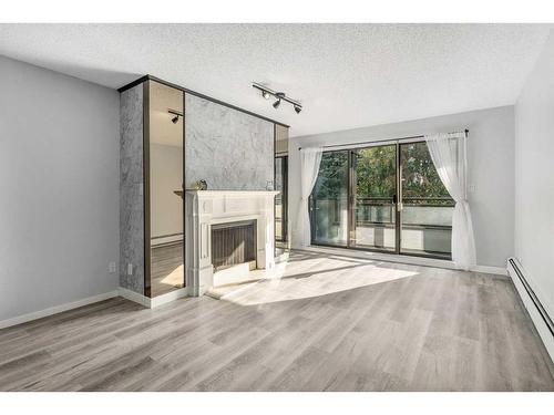 207-3730 50 Street Nw, Calgary, AB - Indoor Photo Showing Living Room With Fireplace