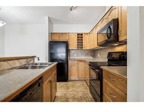 #216-72 Quigley Drive, Cochrane, AB - Indoor Photo Showing Kitchen With Double Sink