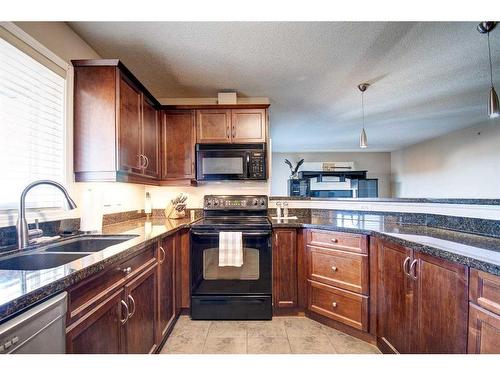 7413-304 Mackenzie Way Sw, Airdrie, AB - Indoor Photo Showing Kitchen With Double Sink