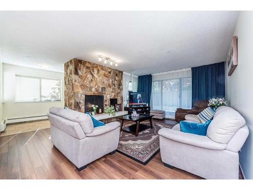 102-3719B 49 Street Nw, Calgary, AB - Indoor Photo Showing Living Room With Fireplace