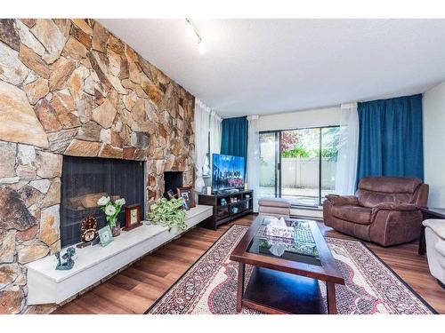 102-3719B 49 Street Nw, Calgary, AB - Indoor Photo Showing Living Room With Fireplace