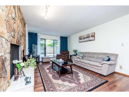 102-3719B 49 Street Nw, Calgary, AB - Indoor Photo Showing Living Room With Fireplace