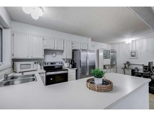 16 Woodmont Green Sw, Calgary, AB - Indoor Photo Showing Kitchen With Stainless Steel Kitchen With Double Sink