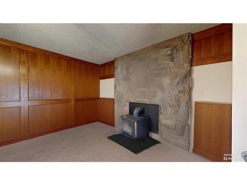 103 Slade Drive, Nanton, AB - Indoor Photo Showing Other Room With Fireplace