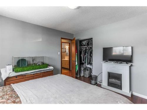 3036 33A Street Se, Calgary, AB - Indoor Photo Showing Bedroom With Fireplace