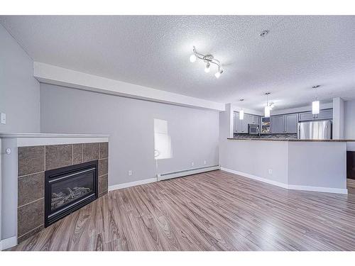 1304-8810 Royal Birch Boulevard Nw, Calgary, AB - Indoor Photo Showing Living Room With Fireplace