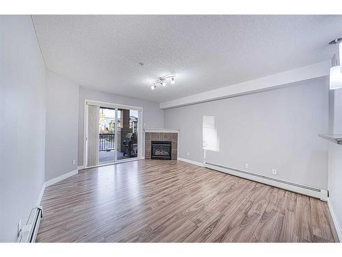 1304-8810 Royal Birch Boulevard Nw, Calgary, AB - Indoor Photo Showing Living Room With Fireplace