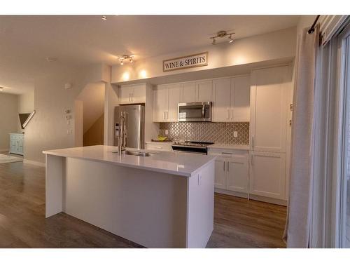 2206 Jumping Pound Common, Cochrane, AB - Indoor Photo Showing Kitchen With Stainless Steel Kitchen With Double Sink With Upgraded Kitchen