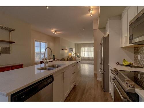 2206 Jumping Pound Common, Cochrane, AB - Indoor Photo Showing Kitchen With Double Sink