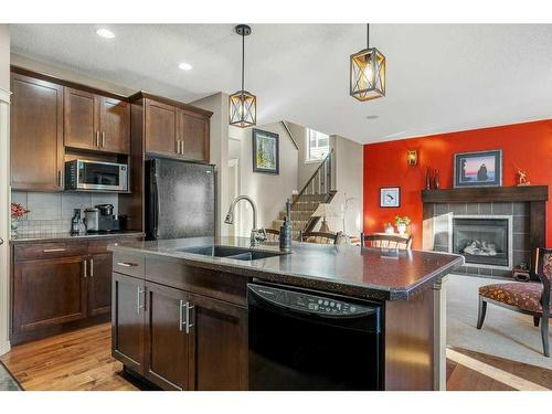 32 St Moritz Terrace Sw, Calgary, AB - Indoor Photo Showing Kitchen With Fireplace With Double Sink