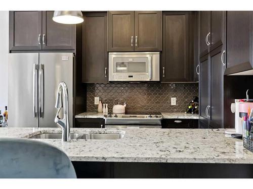 311-39 Quarry Gate Se, Calgary, AB - Indoor Photo Showing Kitchen With Stainless Steel Kitchen With Double Sink With Upgraded Kitchen