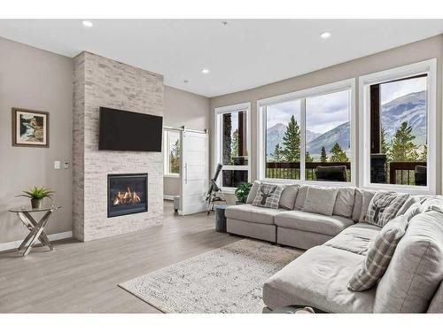 115-106 Stewart Creek Rise, Canmore, AB - Indoor Photo Showing Living Room With Fireplace