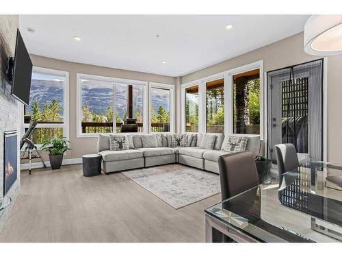 115-106 Stewart Creek Rise, Canmore, AB - Indoor Photo Showing Living Room With Fireplace