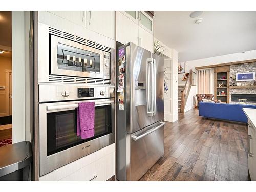 201 Kinniburgh Cove, Chestermere, AB - Indoor Photo Showing Kitchen With Fireplace