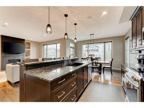 222 Aspen Stone Way Sw, Calgary, AB - Indoor Photo Showing Kitchen With Fireplace With Double Sink