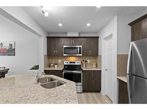 345 Hillcrest Square Sw, Airdrie, AB - Indoor Photo Showing Kitchen With Double Sink With Upgraded Kitchen