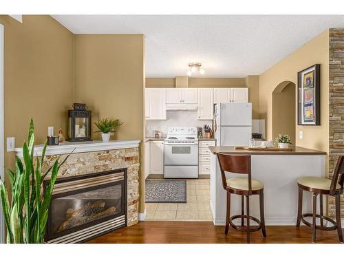 208 Stonemere Place, Chestermere, AB - Indoor Photo Showing Kitchen With Fireplace