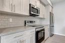 113-4150 Seton Drive Se, Calgary, AB  - Indoor Photo Showing Kitchen With Stainless Steel Kitchen 