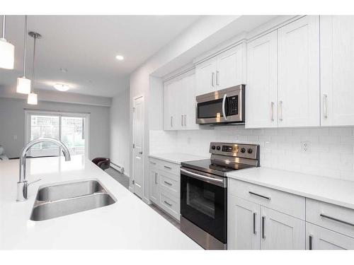 113-4150 Seton Drive Se, Calgary, AB - Indoor Photo Showing Kitchen With Stainless Steel Kitchen With Double Sink With Upgraded Kitchen