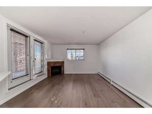 2126-10 Prestwick Bay Se, Calgary, AB - Indoor Photo Showing Other Room With Fireplace