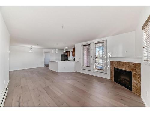 2126-10 Prestwick Bay Se, Calgary, AB - Indoor Photo Showing Living Room With Fireplace