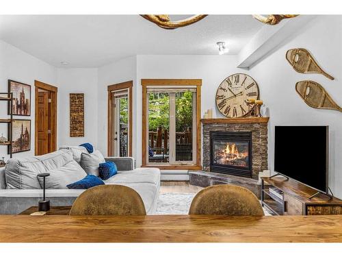 107-155 Crossbow Place, Canmore, AB - Indoor Photo Showing Living Room With Fireplace