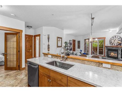 107-155 Crossbow Place, Canmore, AB - Indoor Photo Showing Kitchen With Fireplace