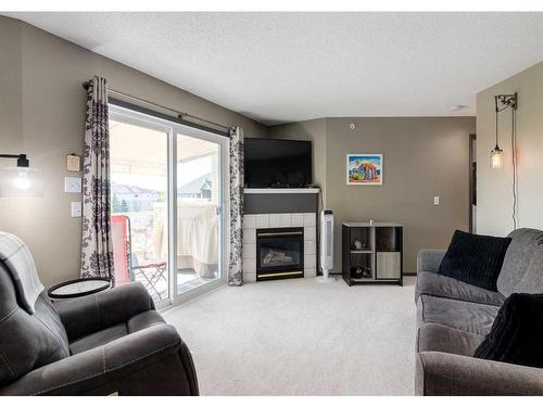 410-6000 Somervale Court Sw, Calgary, AB - Indoor Photo Showing Living Room With Fireplace