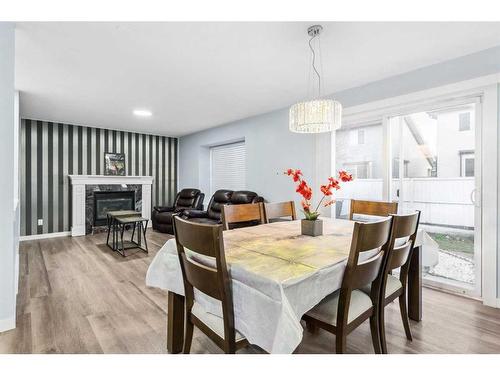 250 Luxstone Road Sw, Airdrie, AB - Indoor Photo Showing Dining Room With Fireplace