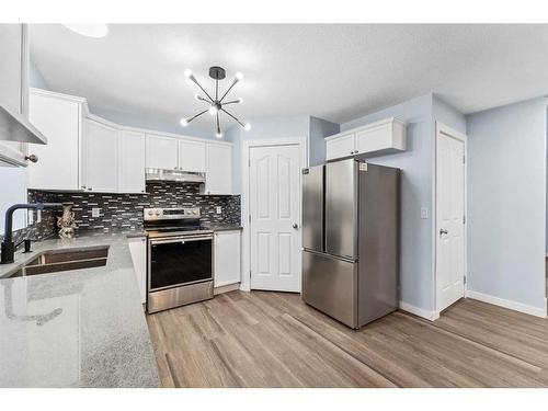 250 Luxstone Road Sw, Airdrie, AB - Indoor Photo Showing Kitchen With Stainless Steel Kitchen With Double Sink With Upgraded Kitchen