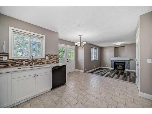 27 Canoe Circle Sw, Airdrie, AB - Indoor Photo Showing Kitchen With Fireplace