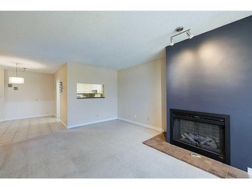 403-3747 42 Street Nw, Calgary, AB - Indoor Photo Showing Living Room With Fireplace